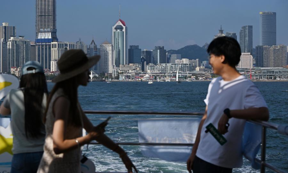 Tourists enjoy the views by boat in Qingdao, east China's Shandong Province, Aug. 26, 2026. (Xinhua/Li Ziheng)