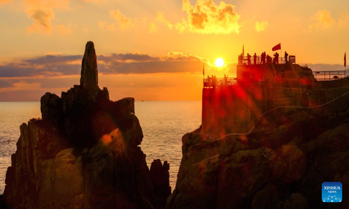People capture sea views at sunrise in Rongcheng, east China's Shandong Province, Oct. 10, 2026. (Xinhua/Chen Yehua)