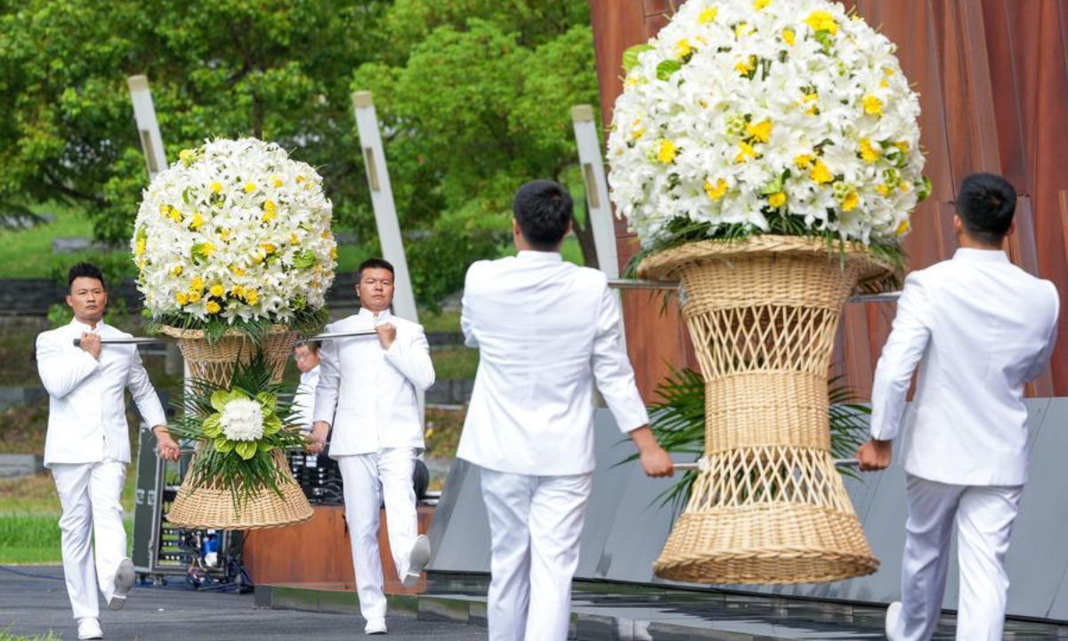 Staff members present flower baskets during a ceremony marking the 81st anniversary of the victory of the Chinese People's War of Resistance against Japanese Aggression and the World Anti-Fascist War at the Memorial Hall of the Victims in Nanjing Massacre by Japanese Invaders, in Nanjing, east China's Jiangsu Province, Sept. 3, 2026. (Xinhua/Li Bo)