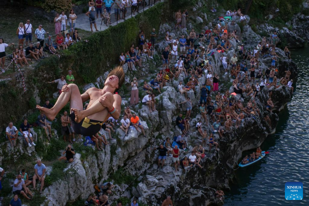 A participant jumps into the River Soca from a 17-meter-high bridge during a traditional jumping event in Kanal ob Soci, Slovenia, on Aug. 16, 2026. (Photo by Zeljko Stevanic/Xinhua)