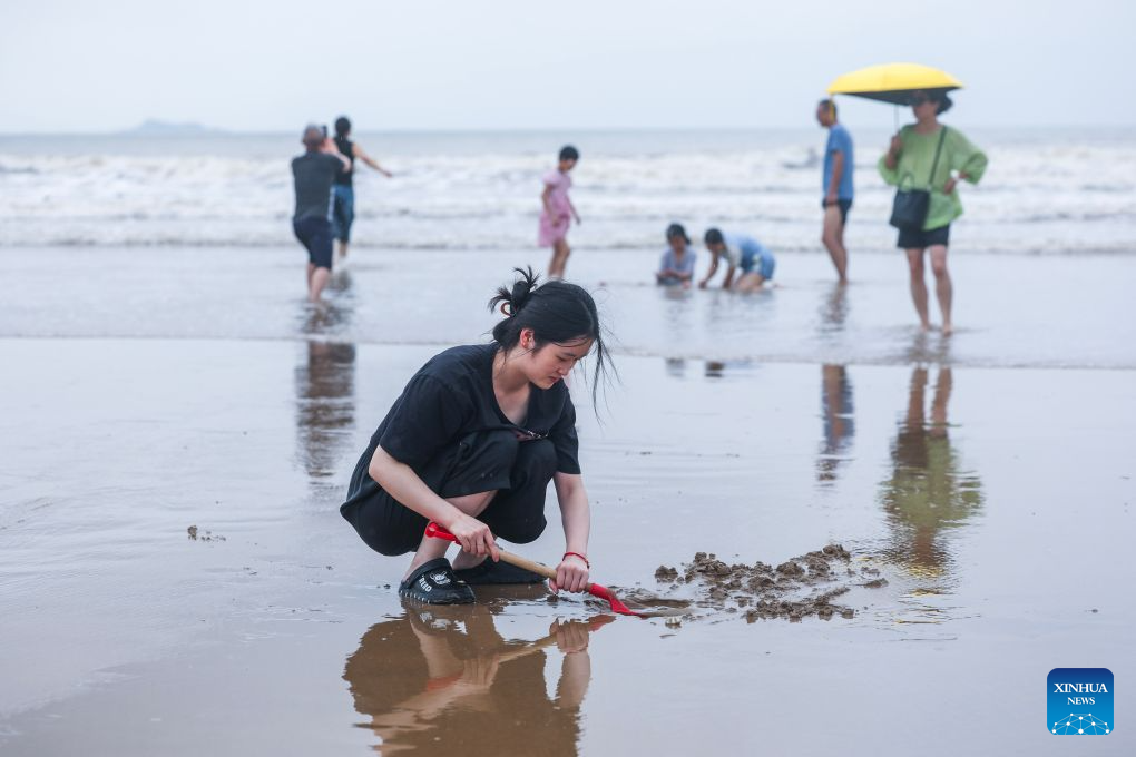 People have fun at the Nansha scenic area in Zhujiajian of Zhoushan City, east China's Zhejiang Province, Aug. 12, 2026.
The Nansha scenic area reopened to the public on Wednesday following necessary safety checks and maintenance after Typhoon Dolphin weakened. (Xinhua/Xu Yu)
