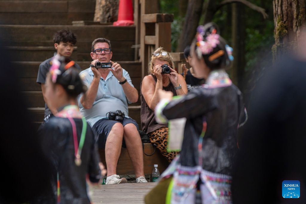 Visitors enjoy a folk performance at Basha Village in Congjiang County of Qiandongnan Miao and Dong Autonomous Prefecture, southwest China's Guizhou Province, Aug. 22, 2026. Located seven kilometers away from the county seat of Congjiang, Basha Village has attracted an increasing number of overseas tourists with its charming scenery and simple folk customs recently.
Consisting of five hamlets and inhabited by the Miao people, the village was included in the first batch of China's traditional villages in 2012. Riding the viral Chinamaxxing wave on social media, foreign tourists have come here to experience ancient ways of life and profound cultural heritage.
Data from the National Immigration Administration shows that China recorded 22.91 million inbound foreign visits in the first half of this year, up 20.4 percent year on year. (Photo by Wu Dejun/Xinhua)