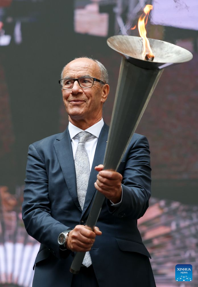 Leonz Eder, president of FISU, holds the torch from the first World University Games held in Turin in 1959 during the flame collection ceremony for the Changchun 2027 Winter Universiade in Turin, Italy, Oct. 8, 2026. (Xinhua/Wang Kaiyan)