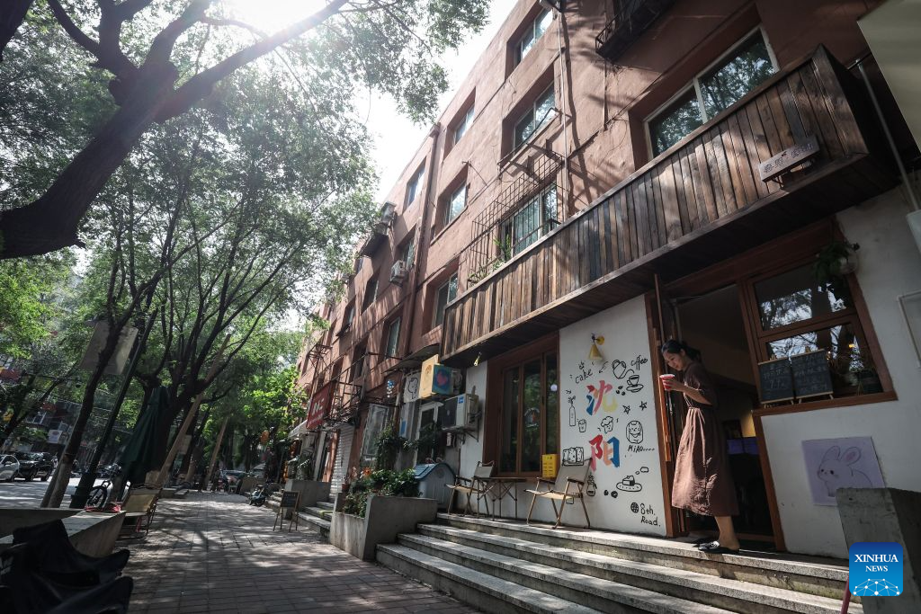 A customer walks out a coffee shop on Bajing Street, Shenyang City, northeast China's Liaoning Province, Aug. 1, 2026. A pack of coffee shops of varying styles on Bajing Street in Shenyang have breathed new life into the old city. Once quiet but obsolete, this historic street is now a vibrant new landmark of culture and tourism that attracts thousands of young visitors every day. Each coffee shop here tells a different story of how a city grows in time. (Xinhua/Pan Yulong)