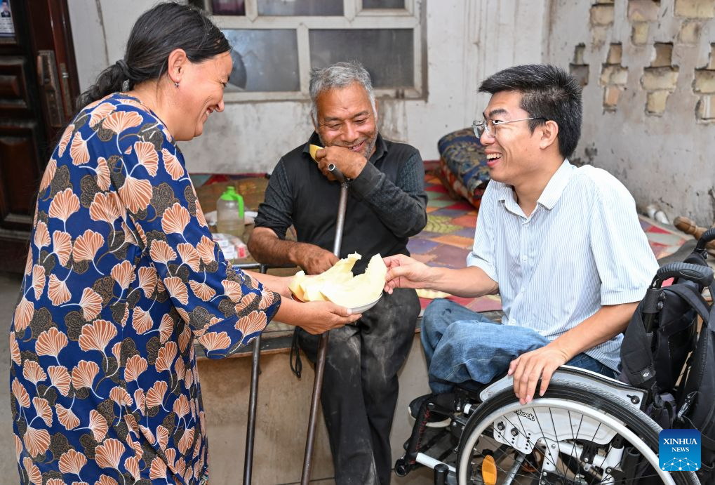 A villager (L) treats Li Chuangye (R) with sliced melon after he rendered medical care for a family member with disabilities at her home in a village of Bexkant Town, Shache County of northwest China's Xinjiang Uygur Autonomous Region, July 26, 2026. Li Chuangye cannot walk on his feet like most people. Instead, he moves forward in a squatting position, lifting his feet in turn with his hands, and swinging his small body, one twist after another.
This 38-year-old doctor hails from a poor family in Henan Province in central China. When Li was seven months old, he contracted polio, a disease that once posed a major health threat to children. China launched a nationwide anti-polio immunization campaign in the 1960s and made huge progress. It was declared polio-free by the World Health Organization in 2000, but sporadic cases still affected unlucky children like Li in the late 1980s.
As a result, he is paralyzed from the waist down, and his height is less than half that of an ordinary person. Li's childhood was marked by a continuous struggle with illness and hardship.
He began primary school at 16 and progressed quickly, skipping several grades through intensive study. He set a clear goal: to study medicine. In 2013, Li was admitted to a medical college, and three years later, he was enrolled in the clinical medicine program of Henan University.
Now, in Bexkant, a remote town on the edge of the Taklimakan Desert in northwest China's Xinjiang Uygur Autonomous Region, Li runs a clinic as a certified physician, becoming a trusted healer for his neighbors.
Li's clinic covers an area of 300 square meters and features a consultation area, an infusion room, a pharmacy and a sign at the entrance reading 24-Hour Medical Service.
Li often attends to patients late into the night and frequently visits surrounding villages to provide medical care to residents who have difficulty traveling. He also offers medical care free of charge for the disabled and at half-price for the impoverished.
After his story gained attention online, he declined all donations from netizens. Helping people with disabilities is like helping my former self. Now that I am in a position to help others, I should do more, Li said. (Xinhua/Hu Huhu)