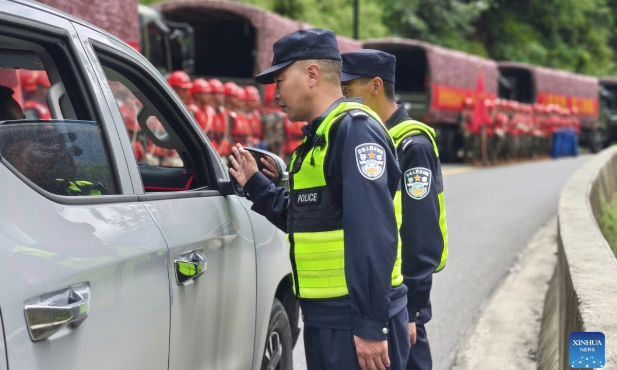 Police officers work on a highway leading to the Gyirong Port in Xigaze, southwest China's Xizang Autonomous Region, on Aug. 27, 2026. A total of 164 traffic police officers have been deployed to the mudslide-stricken areas in Gyirong to ensure the orderly movement of emergency response and supply vehicles. (Xinhua)