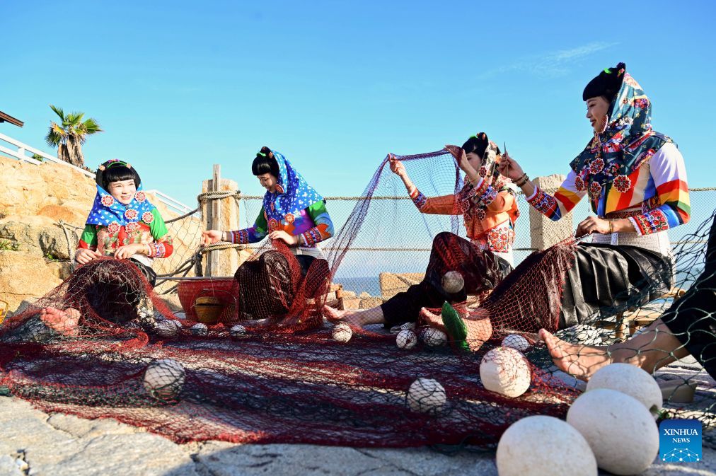 Performers demonstrate net weaving at a scenic spot in Dazuo Village of Hui'an County, southeast China's Fujian Province, Aug. 17, 2026. Dazuo Village is surrounded by the sea on three sides. In recent years, the village has focused on cultivating the traditional customs, launching experiential activities such as net weaving and travel photography to attract tourists. (Xinhua/Lin Shanchuan)