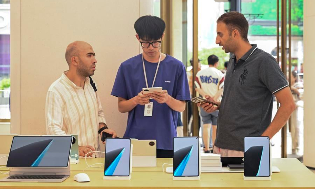 Foreign tourists learn about products at a Huawei store on Nanjing Road in east China's Shanghai, July 28, 2026. (Xinhua/Chen Haoming)