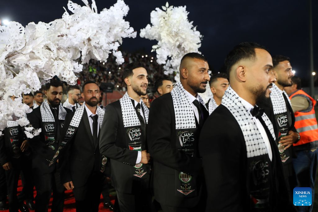 Grooms attend a mass wedding ceremony in Dura near the West Bank city of Hebron, on Sept. 26, 2026. The mass wedding ceremony brought together 88 Palestinian grooms and brides, with thousands of local residents attending the event. (Photo by Mamoun Wazwaz/Xinhua)