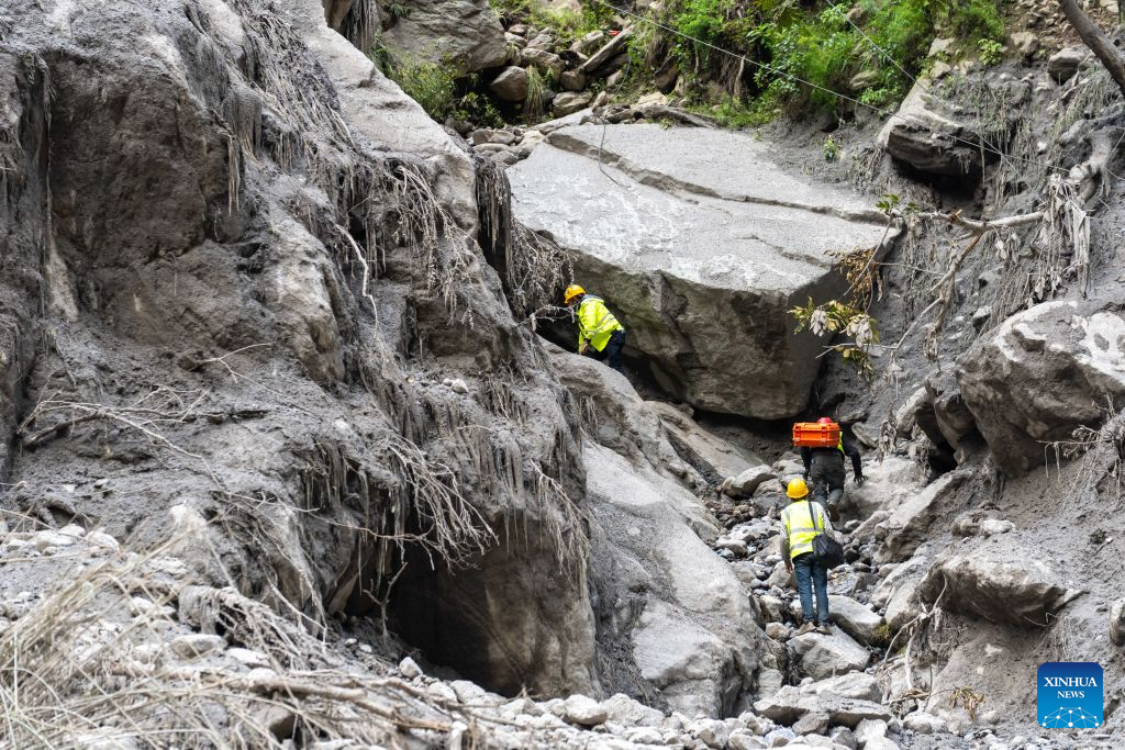 Communication support workers search for damaged optical cables at the mudslide-hit area in Gyirong County, southwest China's Xizang Autonomous Region, Aug. 30, 2026. A newly-built 4G/5G base station, approximately 900 meters from the mudslide-hit Gyirong Port in Gyirong County, was put into use on Sunday, ensuring more stable communication signals at the core rescue site. (Xinhua/Tenzing Nima Qadhup)