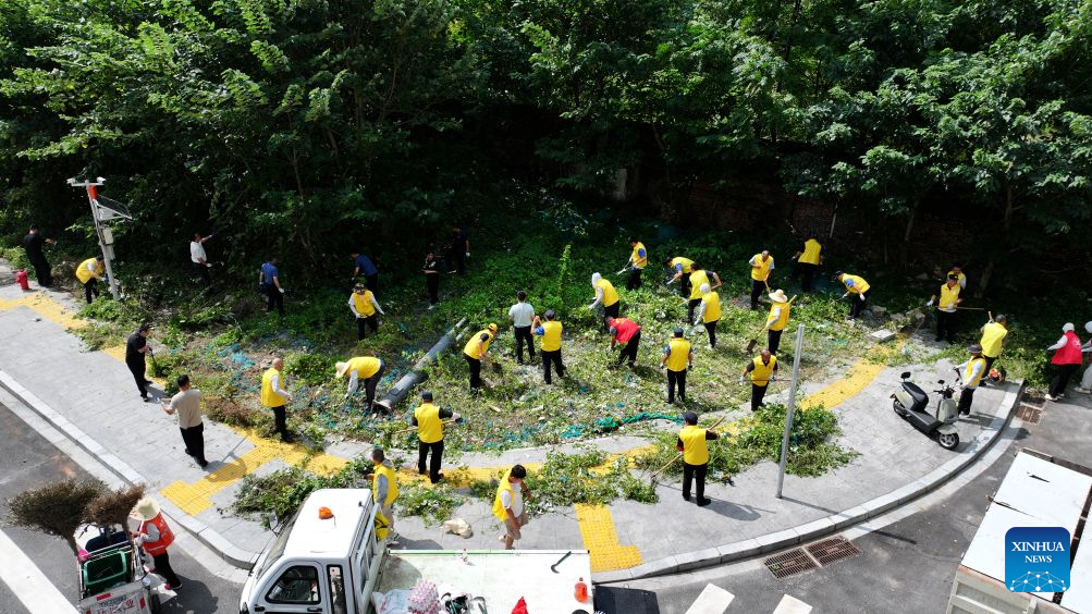 Community staff clean a temporary garbage dump in Xihu District of Nanchang, east China's Jiangxi Province, Aug. 8, 2026.
As a form of grassroots community governance, roundtable discussions are widely organized in residential communities across the city to address residents' concerns, resolve neighborhood disputes, and tackle community issues. (Photo by Sun Haojie/Xinhua)