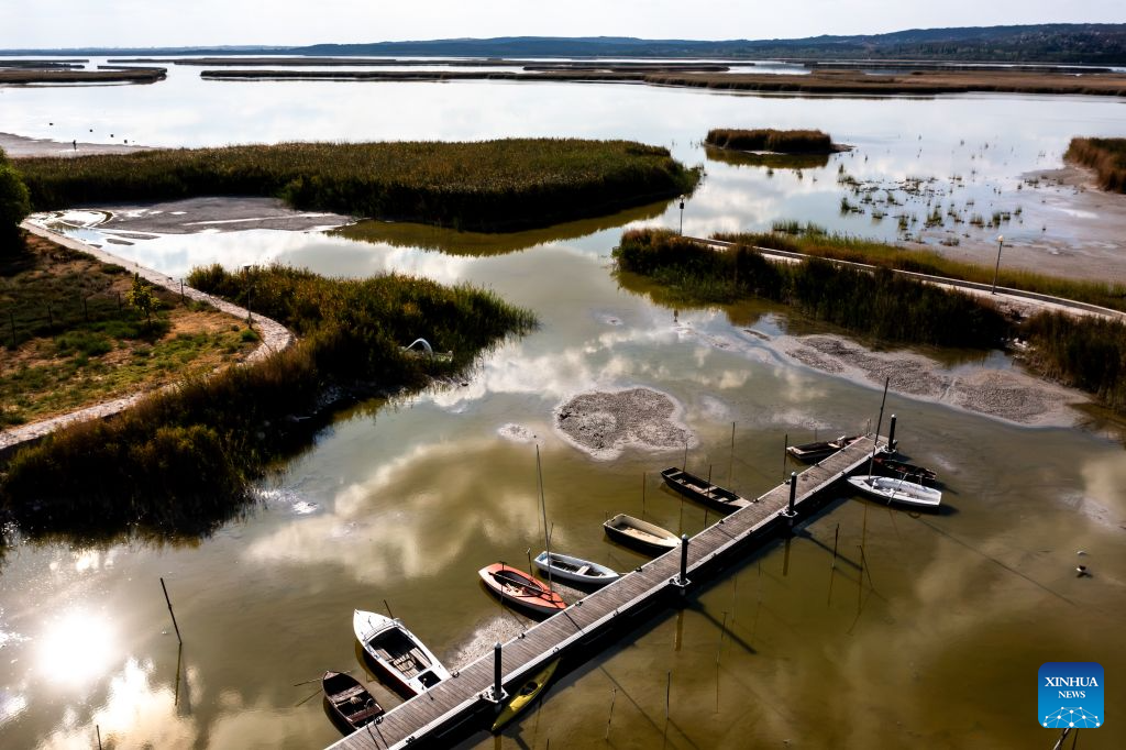 An aerial drone photo taken on Aug. 26, 2026 shows a dock of the drought-stricken Lake Velence near Gardony, Hungary. Prolonged drought has pushed Lake Velence, one of Hungary's major lakes, to its lowest level on record. By Aug. 26, the water level had fallen to 16 centimeters, exposing the lakebed along several shallow stretches. (Photo by David Balogh/Xinhua)