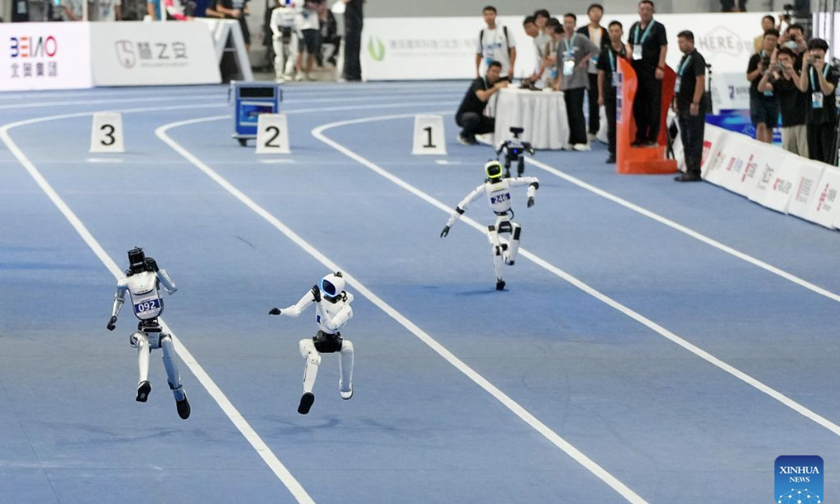 Robots compete during the 100m-Small Group heats of the 2nd World Humanoid Robot Games in Beijing, capital of China, Aug. 25, 2026. (Xinhua/Ju Huanzong)