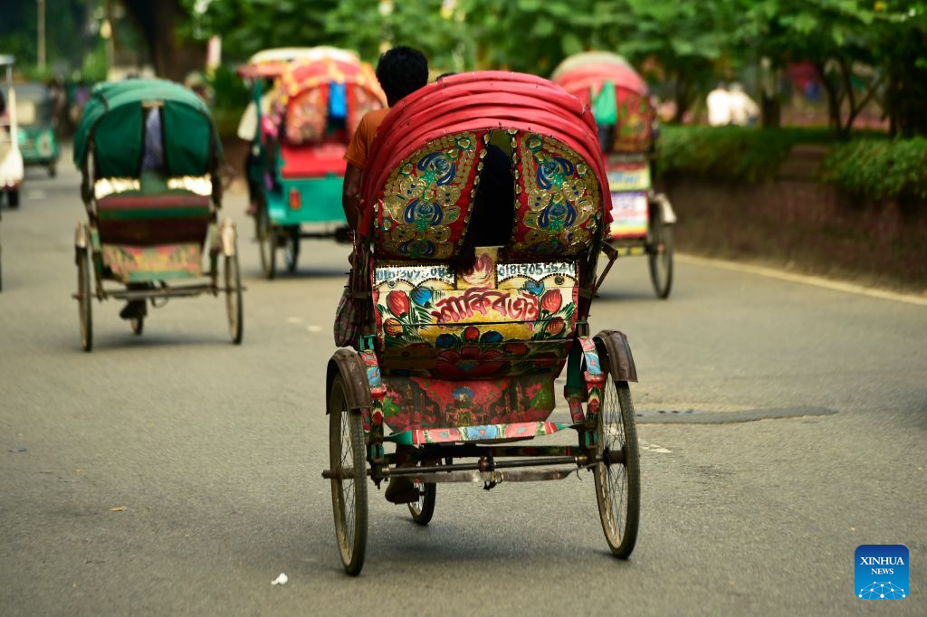 This photo taken on Aug. 22, 2026 shows rickshaws on a street in Dhaka, Bangladesh. In 2023, UNESCO announced the inclusion of Bangladesh's iconic rickshaws and rickshaw painting in Dhaka on the Representative List of the Intangible Cultural Heritage of Humanity. (Photo by Habibur Rahman/Xinhua)