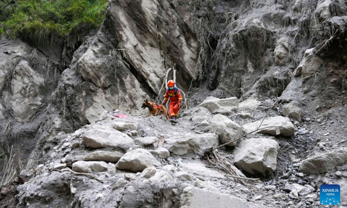 A rescuer and his sniffer dog search for the missing at the mudslide-hit area in Gyirong County, southwest China's Xizang Autonomous Region, Aug. 30, 2026. Rescuers are racing against time and the odds in search of survivors after a devastating mudslide, triggered by an ice-rock avalanche in Nepal, hit the border port of Gyirong in southwest China's Xizang Autonomous Region. (Xinhua/Jigme Dorje)