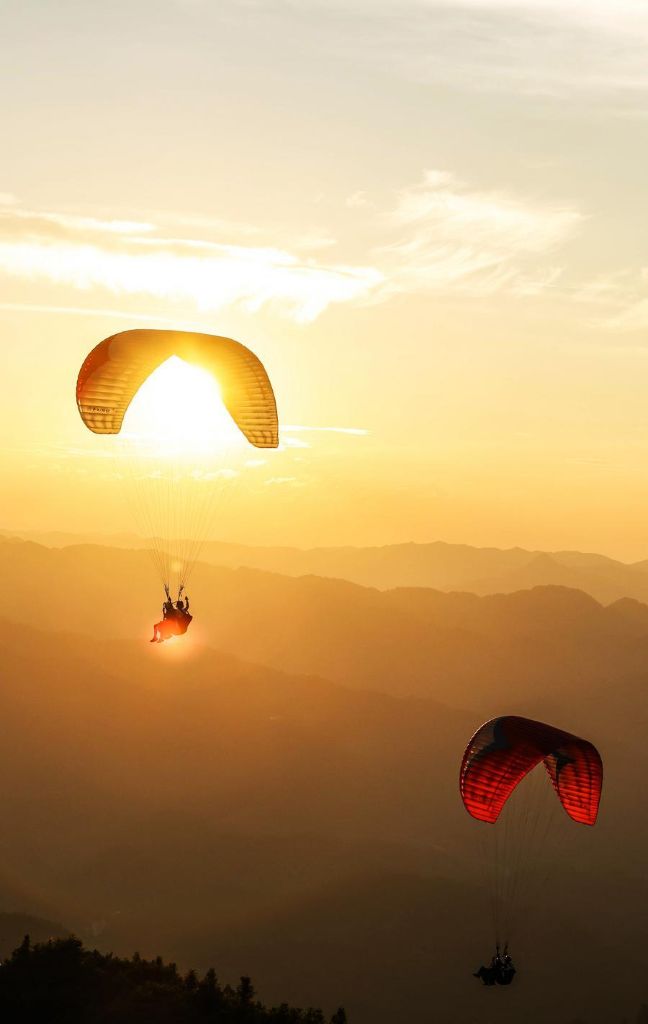 An aerial photo taken on July 30, 2026 shows tourists experiencing paragliding with pilots at a paragliding base in Jiuzhou Town, Huangping County, southwest China's Guizhou Province. (Xinhua/Yang Wenbin)
