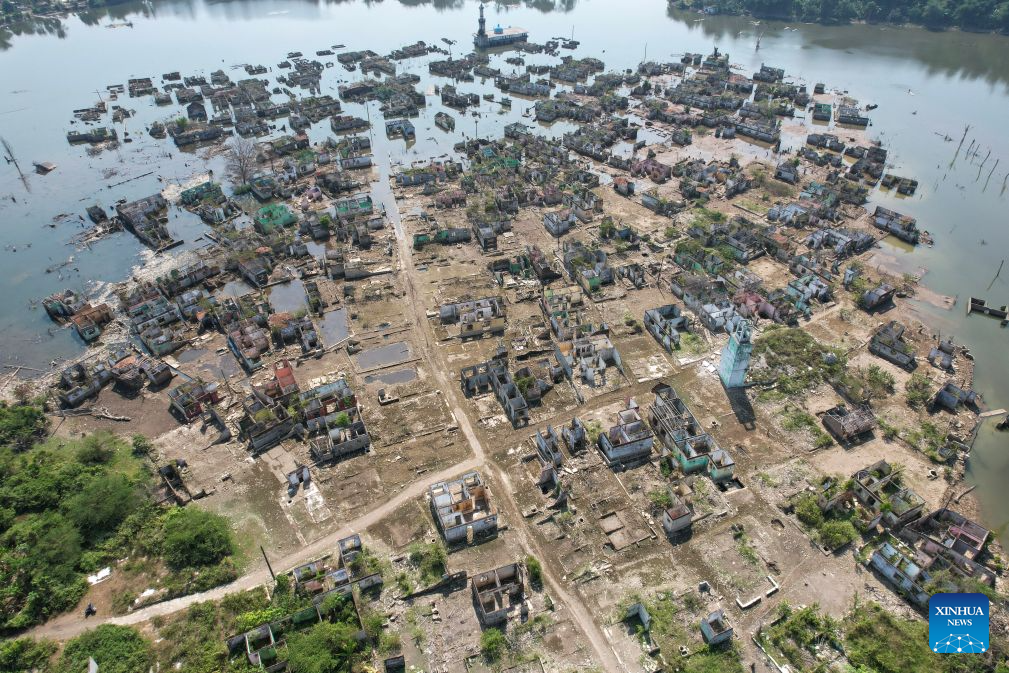 An aerial drone photo taken on July 28, 2026 shows remains of houses re-emerging as the reservoir's water level drops in Lebak regency, Banten province, Indonesia. Due to the impact of El Nino, the dry season in Indonesia has been more intense and prolonged this year, with heightened risks of wildfires and droughts. (Xinhua/Veri Sanovri)
