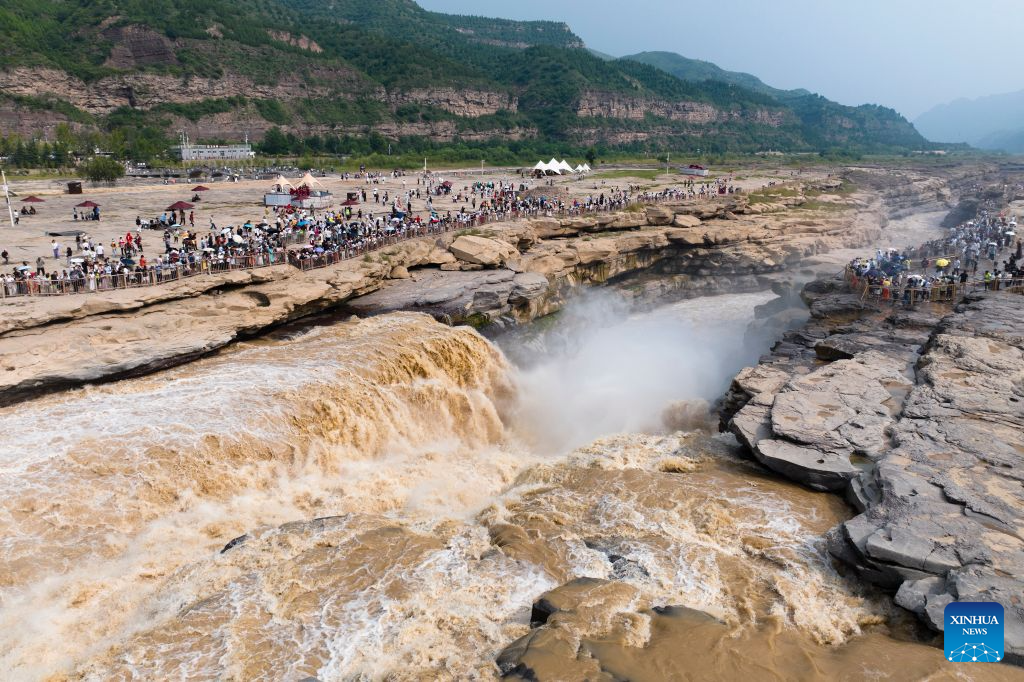 An aerial drone photo taken on Aug. 10, 2026 shows tourists visiting the Yellow River's Hukou Waterfall in northwest China's Shaanxi Province. (Xinhua/Shao Rui)