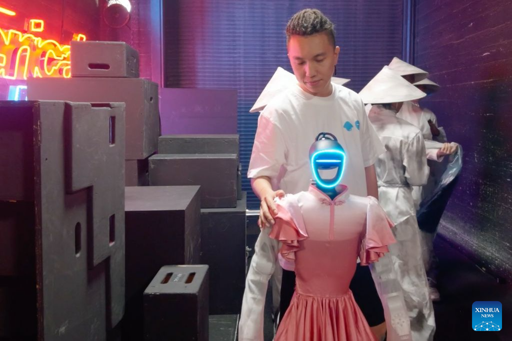 Fang Zhenghua arranges the costume of a robot before a rehearsal for a performance on America's Got Talent, a popular U.S. television talent show, Sept. 22, 2026. (Xinhua)