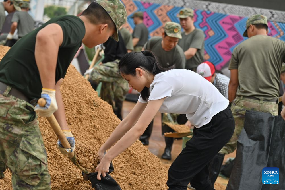 Rescuers prepare sandbags as flood control supplies along the banks of the Mingjiang River in Ningming County, south China's Guangxi Zhuang Autonomous Region, Aug. 24, 2026. Rescue forces have been deployed in Ningming County where typhoon-triggered heavy rainfall caused flood in the Mingjiang River and its tributaries on Sunday. (Xinhua/Zhou Hua)