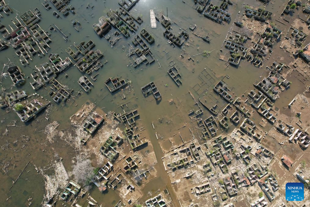 An aerial drone photo taken on July 28, 2026 shows remains of houses re-emerging as the reservoir's water level drops in Lebak regency, Banten province, Indonesia. Due to the impact of El Nino, the dry season in Indonesia has been more intense and prolonged this year, with heightened risks of wildfires and droughts. (Xinhua/Veri Sanovri)