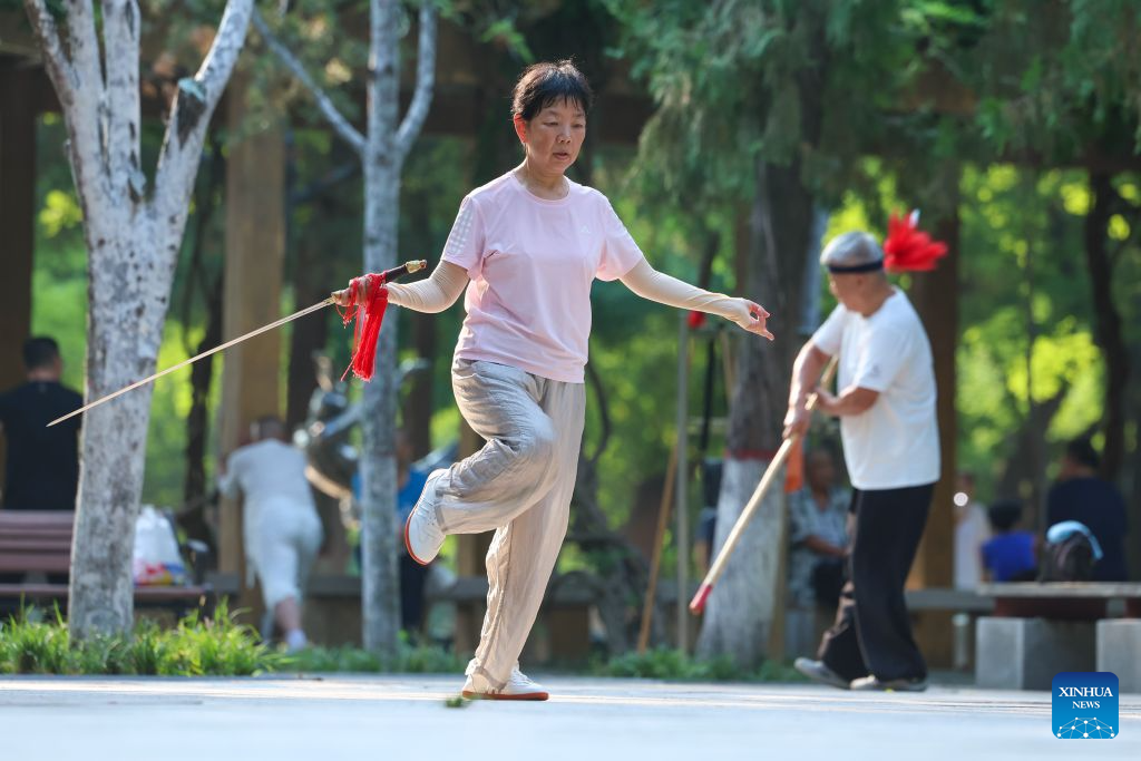 A citizen practices Tai Chi Sword at a park in Shijiazhuang, north China's Hebei Province, Aug. 6, 2026. On the occasion of National Fitness Day, a legacy of the 2008 Beijing Olympics, more people are embracing active lifestyles. (Photo by Liang Zidong/Xinhua)
