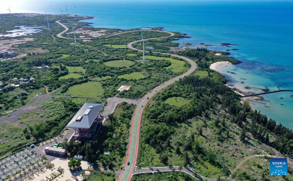 An aerial drone photo taken on July 11, 2026 shows vehicles running on a loop highway in Danzhou, south China's Hainan Province. Hainan is seeing a surge in visitors during the summer holiday season. (Xinhua/Guo Cheng)