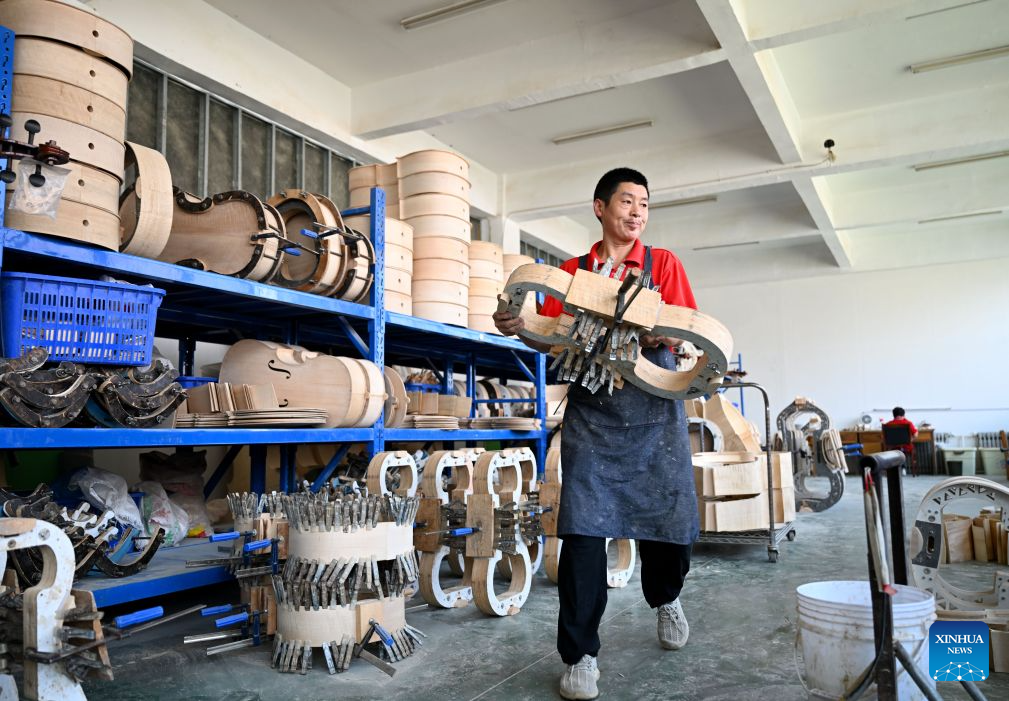 A staff member works at a string instrument manufacturer in Queshan County of Zhumadian City, central China's Henan Province, Sept. 12, 2026. The violin-making industry of Queshan County thrived in recent years as skilled luthiers returned home to start their own businesses. With an annual output of about 400,000 violins, Queshan produces more than 80 percent of made-in-China medium- and high-end violins, violas, cellos, bass and violin accessories. Many violin-related products from Queshan are made for exports to international markets including Italy, the United States, France and Germany. (Xinhua/Hao Yuan)