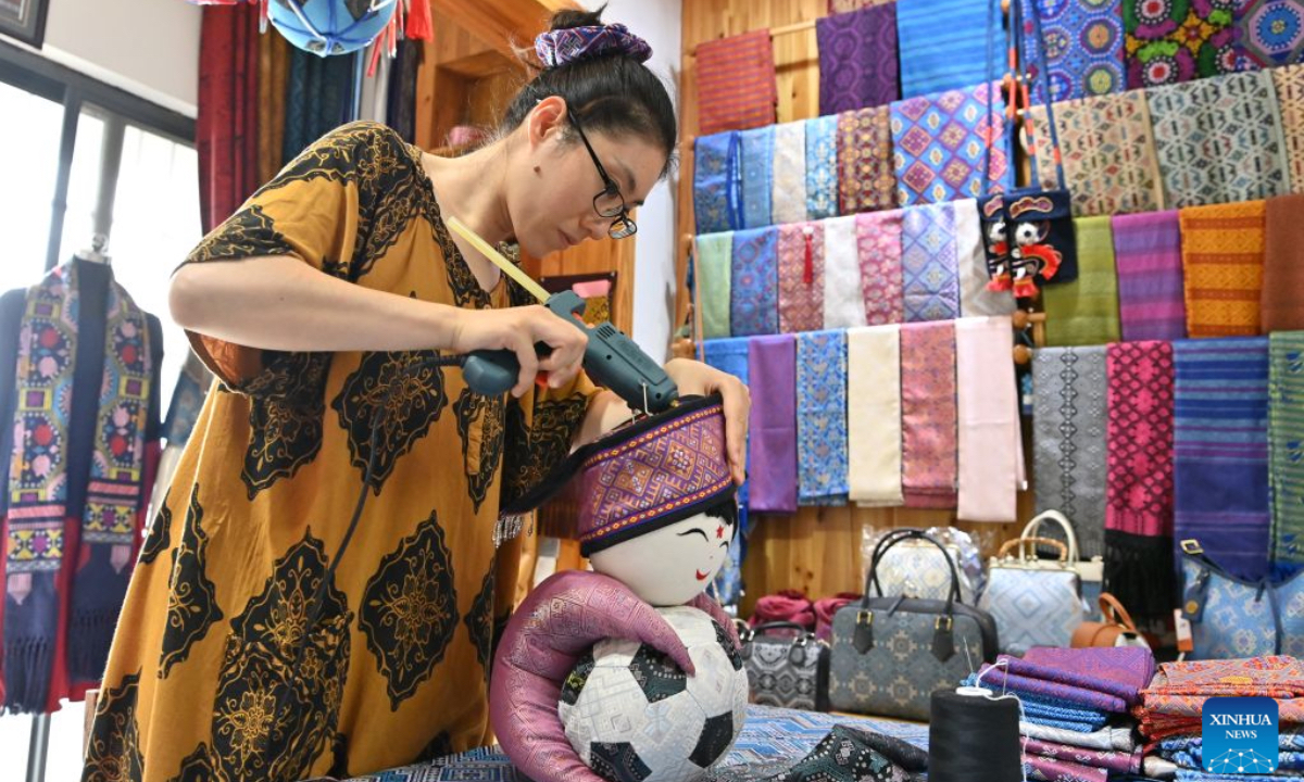 A craftswoman makes handicrafts of Zhuang brocade at a studio in Nanning, south China's Guangxi Zhuang Autonomous Region, June 23, 2026. Known for its vibrant colors and auspicious patterns like dragons and phoenixes, Zhuang brocade is one of the four famous brocades in China. In 2006, Zhuang brocade weaving skill, a craft dating back to the Han Dynasty (202 BC-220 AD), was included in the first batch of national intangible cultural heritage list. Over the years, successive generations of Zhuang brocade weavers in Guangxi, while adhering to ancient techniques, have been constantly innovating the brocade weaving skills and the product development. A wide variety of products have been made from the Zhuang brocade, which are sold well both at home and abroad. (Xinhua/Lu Boan)