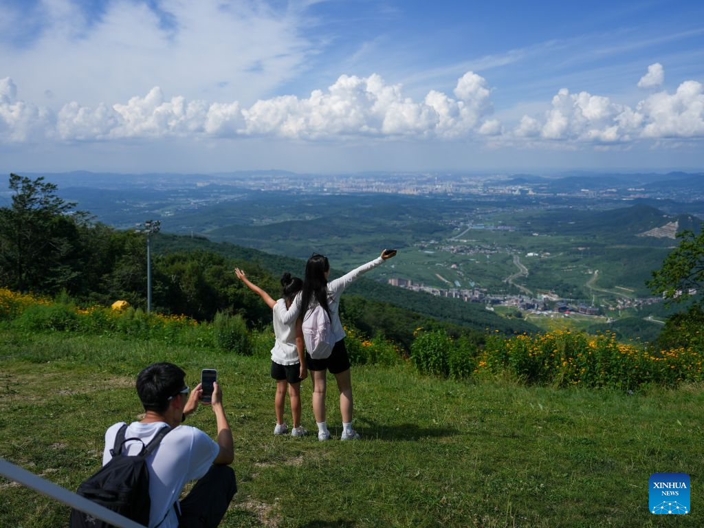 Tourists pose for photos at the Lake Songhua Resort in Jilin City, northeast China's Jilin Province, Aug. 12, 2026. The Lake Songhua Resort, located in Jilin City, is a national-level ski tourism resort. In recent years, relying on its mountain resources, the resort has extended operation in other seasons except for winter, attracting tourists with natural scenery and mountain sports.

Since April 25 this year, the resort has received a total of 200,000 visitors, a year-on-year growth of 20 percent. From popular destination in winter to year-round operation, the tourism potential of the resort is being fully tapped, promoting the high-quality development of the local cultural and tourism industry. (Xinhua/Zhang Nan)