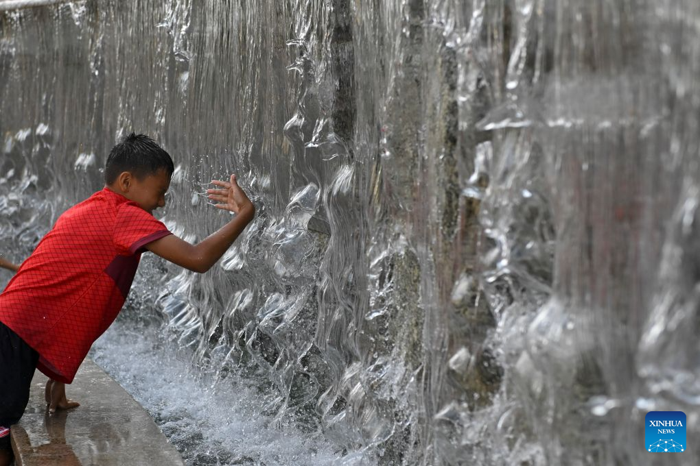 A boy cools off by a fountain near the Red Square amid a heatwave in Moscow, Russia, Aug. 6, 2026. (Photo by Alexander Zemlianichenko Jr/Xinhua)