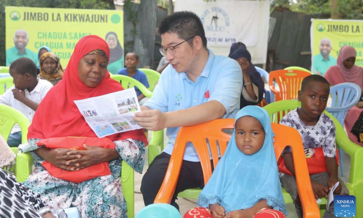 This file photo taken on Oct. 8, 2025 shows Yuan Gang, a radiologist with the 35th Chinese medical team in Zanzibar, talking with a local resident during a community health outreach activity in Zanzibar, Tanzania. (The 35th Chinese medical team in Zanzibar/Handout via Xinhua)