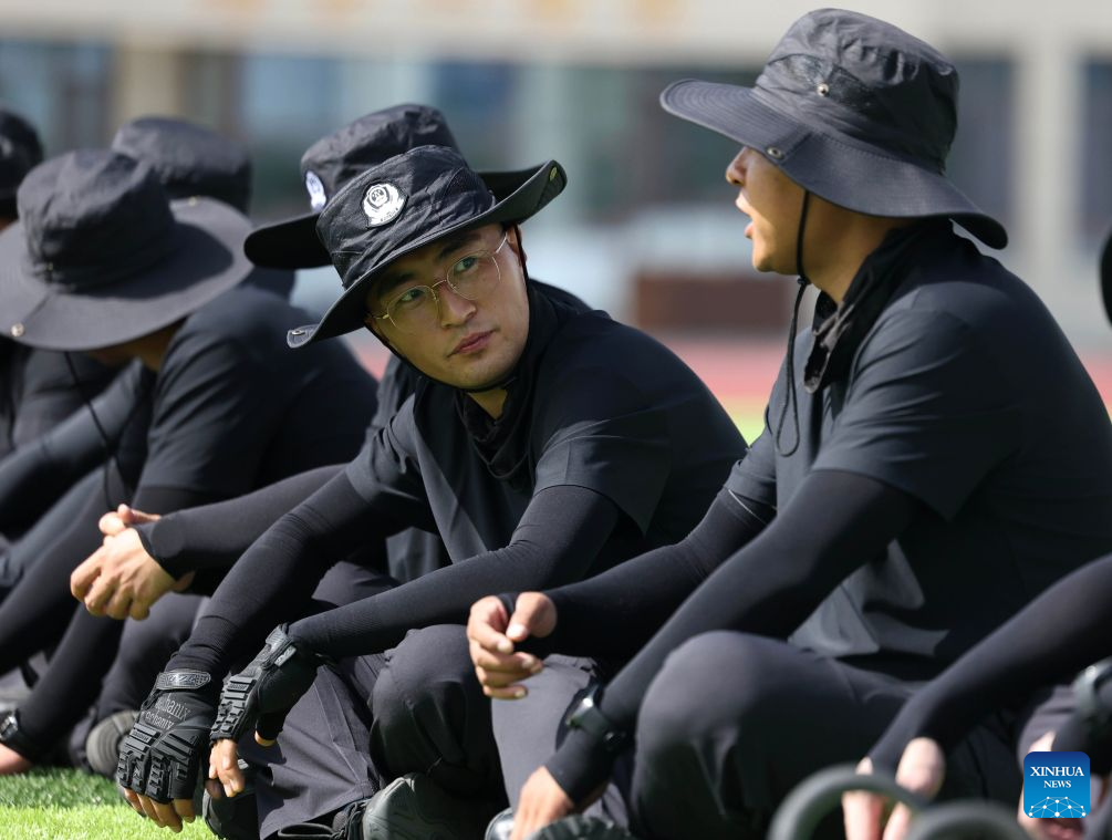 Li Junjie (2nd R) communicates with a colleague at a training ground of the Gansu General Station of Exit and Entry Frontier Inspection in Lanzhou New Area in Lanzhou, northwest China's Gansu Province, July 20, 2026. (Xinhua/Chen Bin)