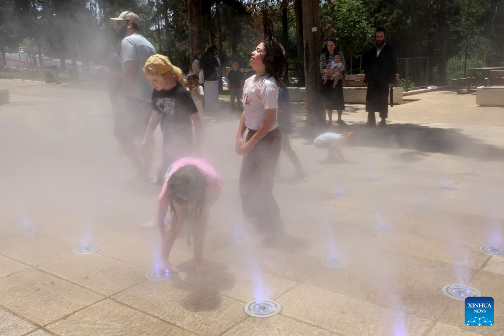 People cool off during a heatwave at a park in Jerusalem, Aug. 2, 2026. A severe heatwave has swept across Jerusalem in recent days. (Photo by Gil Cohen Magen/Xinhua)