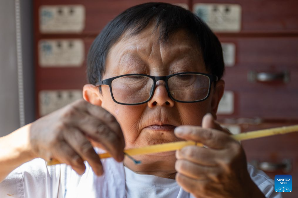 Wang Ju prepares herbal medicine at the clinic in Lianghe Village, Lianghekou Town, Zigui County of Yichang, central China's Hubei Province, Aug. 15, 2026. (Xinhua/Du Zixuan)