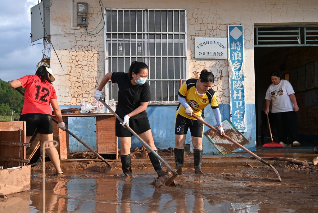 People clean mud after flood in Zhilang Township of Ningming County, south China's Guangxi Zhuang Autonomous Region, Aug. 25, 2026. Continuous heavy rainfall caused by Typhoon Narra, the 19th typhoon of the year, has swept across Ningming County. As of 12:00 p.m. (Beijing Time) on Tuesday, 22,008 stranded civilians had been transferred with the help of rescue and relief forces. (Xinhua/Lu Boan)