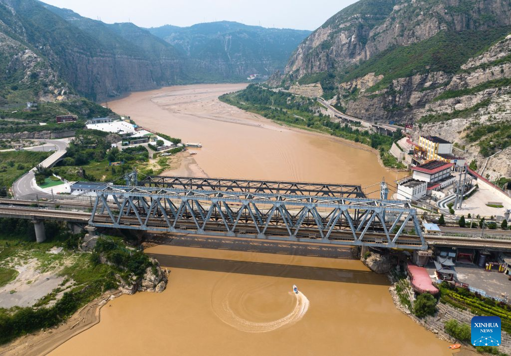 An aerial drone photo taken on Aug. 10, 2026 shows tourists visiting a scenic area of the Yellow River on the border of north China's Shanxi Province and northwest China's Shaanxi Province. With the completion and operation of transport infrastructure, such as the Yanhuang Highway in northwest China's Shaanxi Province and the Yellow River No.1 Tourist Highway in north China's Shanxi Province, tour along the Yellow River has become a popular choice for many travelers in summer. (Xinhua/Shao Rui)