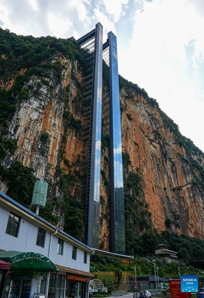 This photo taken on July 31, 2026 shows two cliff elevators at Nizhu River Grand Canyon in Nizhuhe Village of Puli Township, Xuanwei City, southwest China's Yunnan Province. A 288-meter-high cliff elevator began operation recently at Nizhu River Grand Canyon, side by side to another one of its kind already in service since 2022. This is expected to further facilitate local students' trips to their schools.
Nizhuhe Village is a small hamlet nestled in a deep valley carved by the Nizhu River meandering from south to north. In the past, the shortest route from the valley floor to the mountaintop was a steep cliffside path, and the round trip took nearly six hours. Children and their parents had to make the arduous journey at least once every 10 days.
In 2022, a significant change came to this challenging journey. Nizhu River Grand Canyon scenic area was completed and opened, with a 268-meter-high cliff elevator and a cable car system put into operation. The facilities are open free of charge to local villagers.
Today, the combination of sightseeing shuttle vehicles, elevators and cable cars has shortened students' journey to school to about 30 minutes. A dedicated passage has also been set up for the students, with police officers and dedicated staff members as their guardians along the trips. (Xinhua)