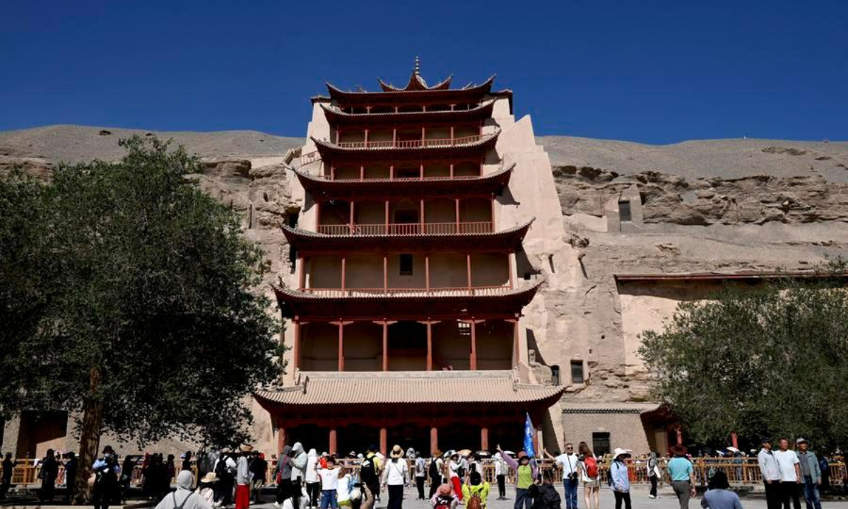 Tourists visit the Mogao Grottoes in Dunhuang, northwest China's Gansu Province, June 21, 2026. (Photo by Zhang Xiaoliang/Xinhua)