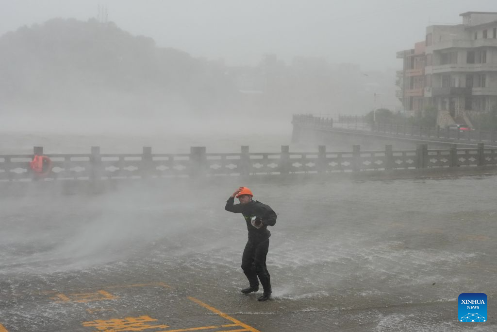 A man is seen as Typhoon Dolphin makes landfall at Dongsha community in Yuhuan, Taizhou, east China's Zhejiang Province, Aug. 9, 2026. Typhoon Dolphin, the 13th typhoon of the year, made landfall at Yuhuan of Taizhou City, east China's Zhejiang Province, at around 5:30 p.m. on Sunday, said the National Meteorological Center (NMC). The maximum sustained wind near the typhoon center hit Force 14, or 42 meters per second, making Dolphin a severe typhoon upon landfall. (Xinhua/Huang Zongzhi)