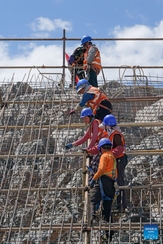 Workers work at the construction site of a pumped-storage power station in Zhangye, northwest China's Gansu Province, Aug. 4, 2026. The construction of the power station started in 2022, and all the four 350,000-kW reversible pump-turbine units are expected to be fully put into operation by 2029. (Xinhua/Liu Keying)