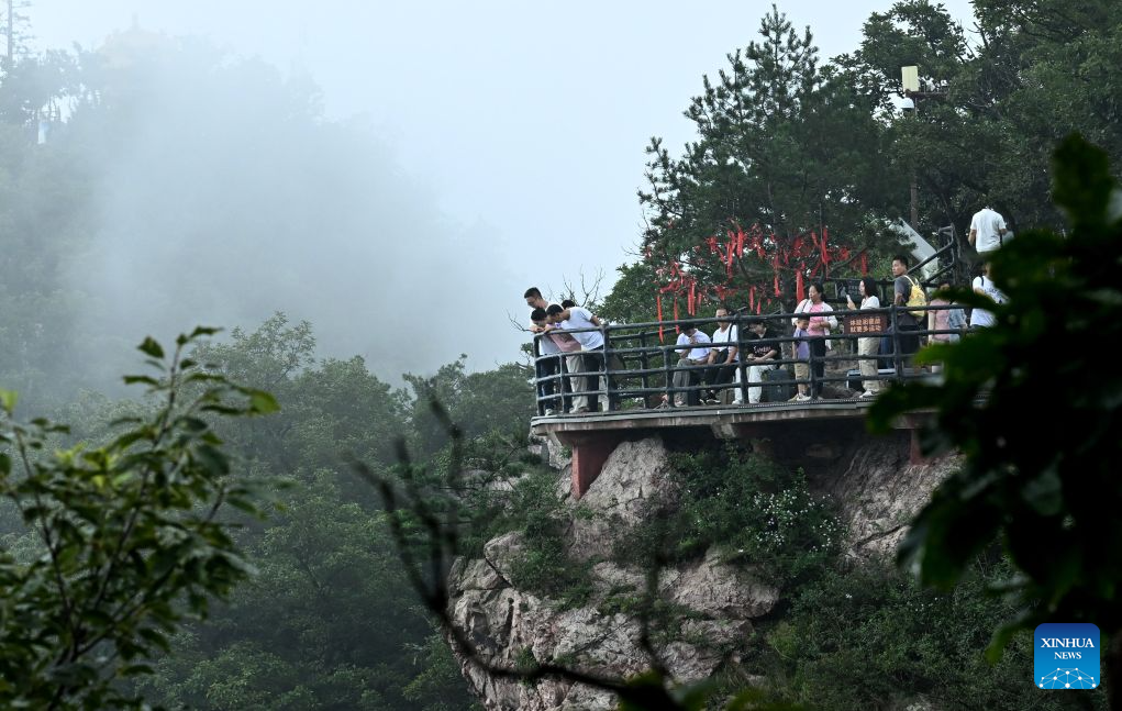Tourists visit the Wangwu Mountain scenic spot in Jiyuan, central China's Henan Province, Aug. 22, 2026. The Wangwu Mountain scenic spot witnesses a tourism boom during the summer vacation. (Xinhua/Zhu Xiang)
