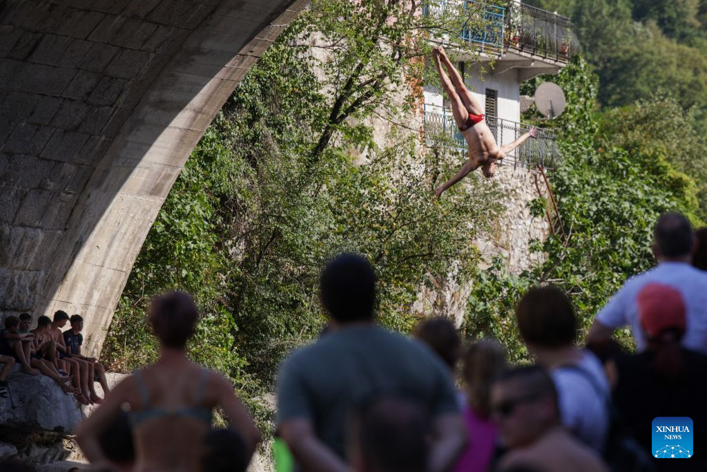 A participant jumps into the River Soca from a 17-meter-high bridge during a traditional jumping event in Kanal ob Soci, Slovenia, on Aug. 16, 2026. (Photo by Zeljko Stevanic/Xinhua)