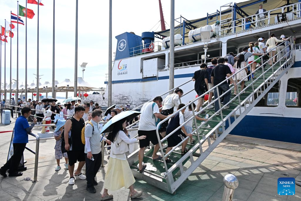 Tourists board a boat at the Qingdao Olympic Sailing and Marine Culture Tourism Area in Qingdao, east China's Shandong Province, Aug. 26, 2026. The Qingdao Olympic Sailing and Marine Culture Tourism Area has been promoting sea sightseeing by launching a number of sightseeing routes linking destinations from Jiaozhou Bay to Zhaitang Island, helping boost local tourism. (Xinhua/Li Ziheng)