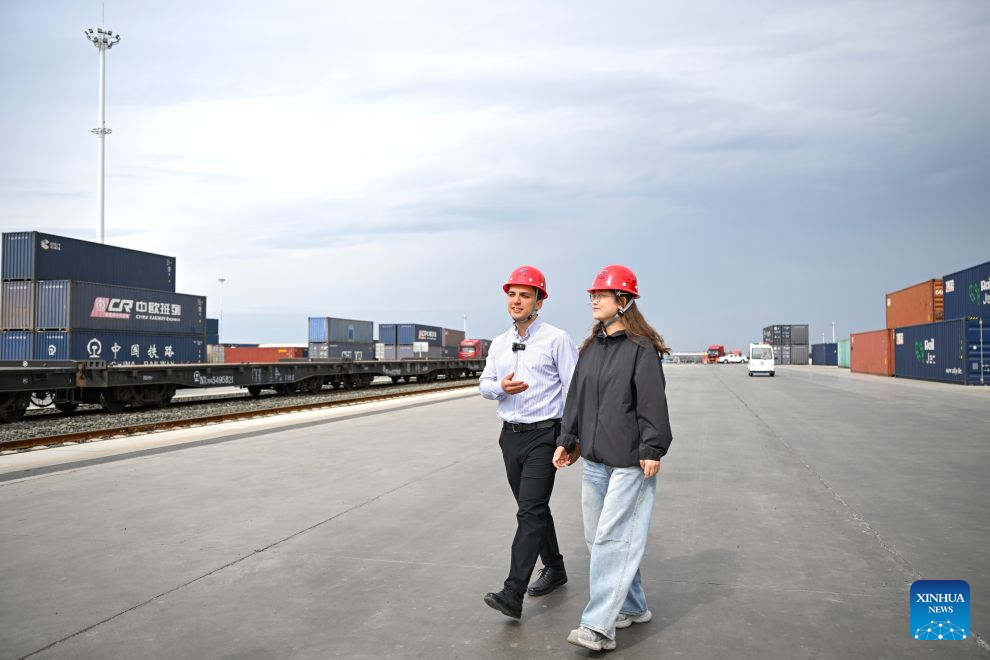 Arseniy Kretov (L) and his Chinese partner walk at the Urumqi cargo terminal of China United International Rail Containers Co., Ltd. (CRIntermodal) in Urumqi, northwest China's Xinjiang Uygur Autonomous Region, Sept. 2, 2026. (Xinhua/Hu Huhu)