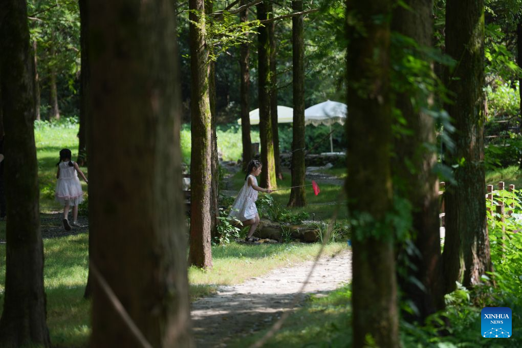 Children play in a forest in Anji County, east China's Zhejiang Province, Aug. 5, 2026. During the summer vacation, Anji County leverages its cool weather and beautiful scenery, attracting numerous tourists to escape the summer heat. (Xinhua/Huang Zongzhi)