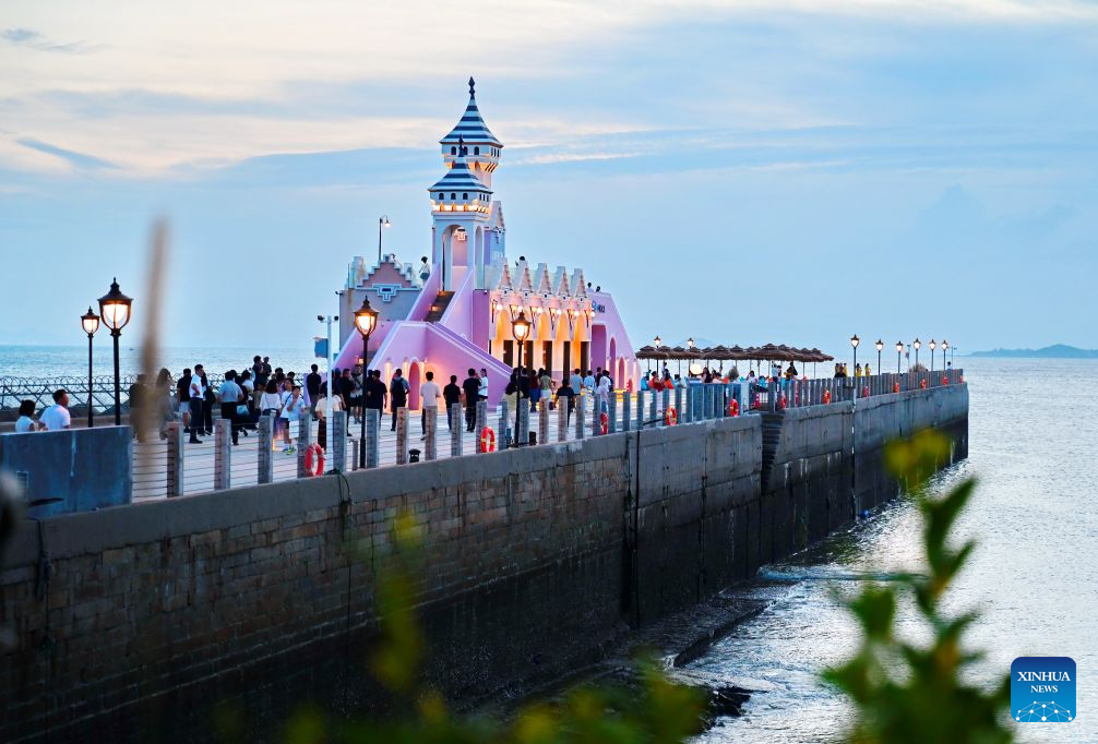 People visit the Chongwu ancient ferry terminal scenic area in Hui'an County of Quanzhou, southeast China's Fujian Province, Aug. 17, 2026. The Chongwu ancient ferry terminal covers an area of 33 mu (about 2.2 hectares) in Hui'an County of southeast China's Fujian Province. In 2024, local authorities transformed it from an idle terminal into a coastal vacation destination that integrates art galleries, a pier runway, trendy restaurants, and family playgrounds. (Xinhua/Lin Shanchuan)