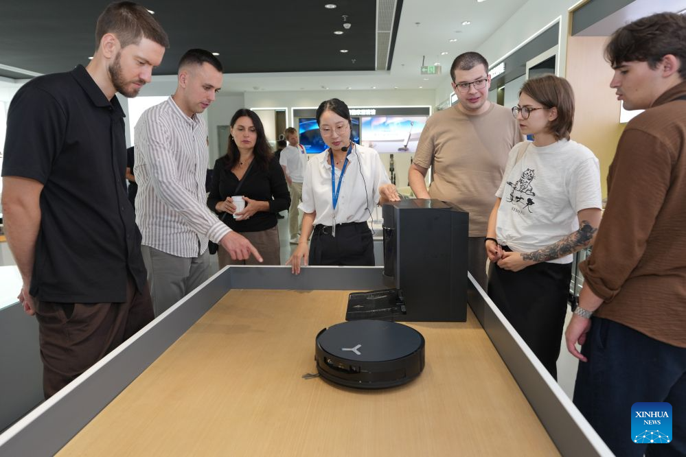 Members of a joint China-Russia media delegation tour Ecovacs Robotics to see their smart robotic vacuum cleaners in Suzhou, east China's Jiangsu Province, Aug. 22, 2026. The delegation visited Suzhou from Aug. 22 to 23, experiencing the charm of China's Jiangnan culture. (Xinhua/Li Bo)