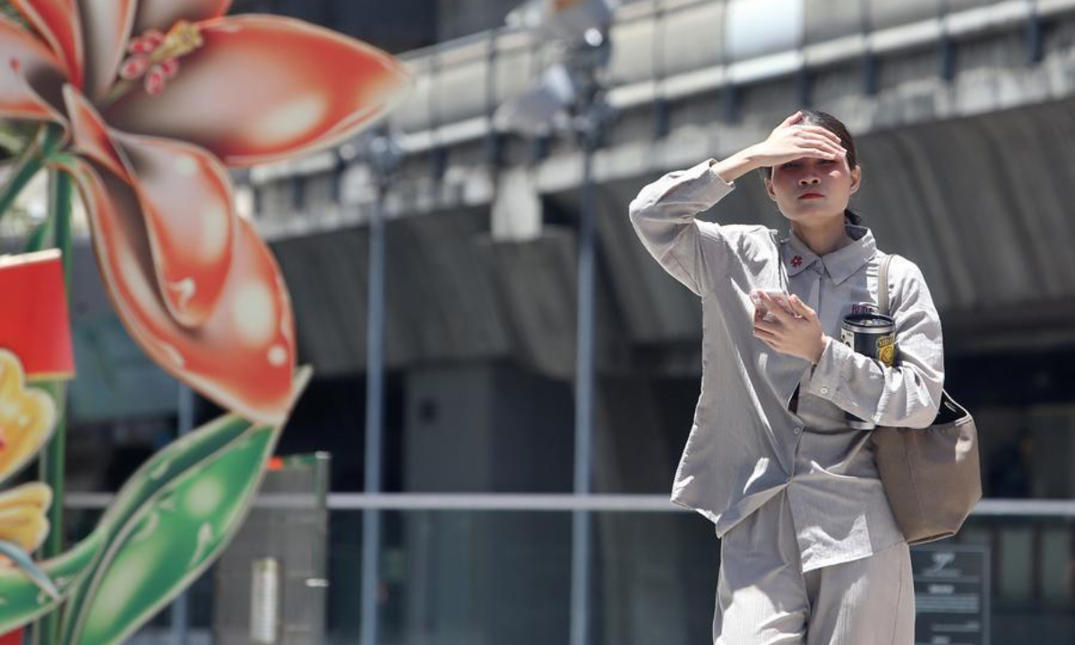 A pedestrian shades her face from the sun on a street in Bangkok, Thailand, June 23, 2026. (Xinhua/Rachen Sageamsak)