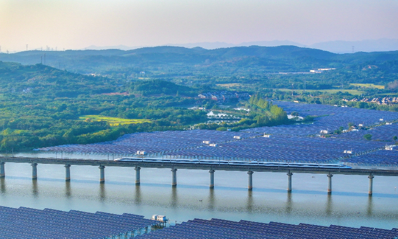 An aerial photo taken on October 8, 2026 shows an integrated fishery and photovoltaic project in Anji county in East China’s Zhejiang Province, framed by high-speed trains nearby. Rural distributed solar projects reflect Anji’s push for green, low-carbon growth that pairs ecological and economic gains. Photo: VCG